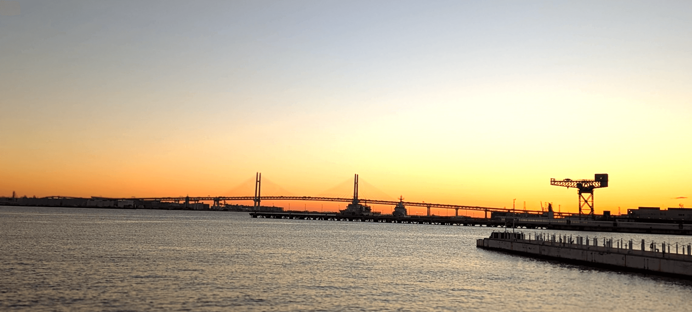 日の出前の横浜の水辺と橋の風景